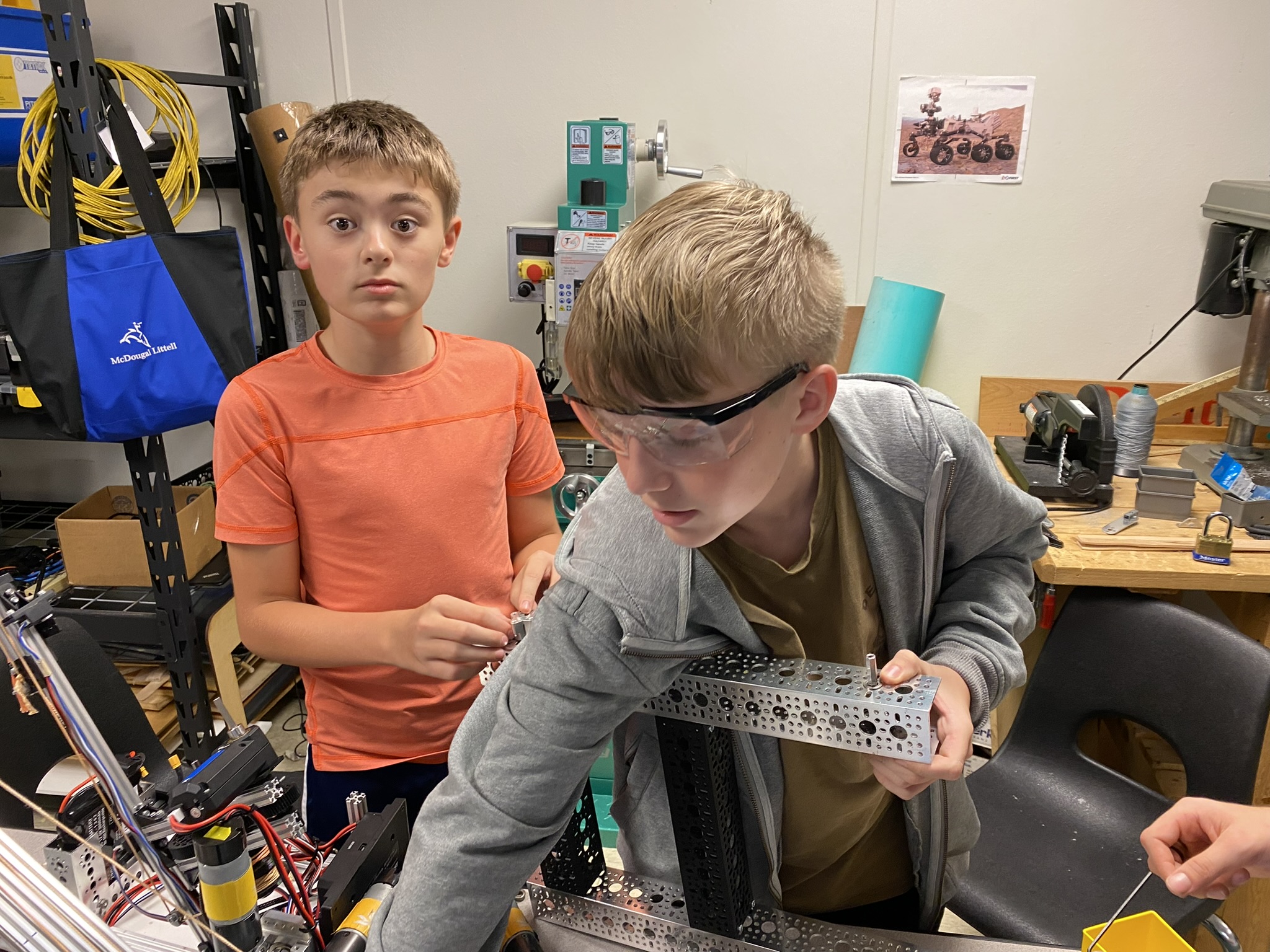 Students soldering electronics on robot